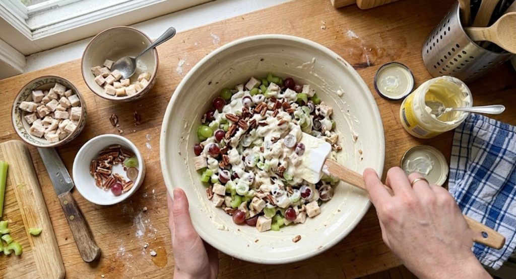 Folding chicken, grapes and pecans into creamy dressing