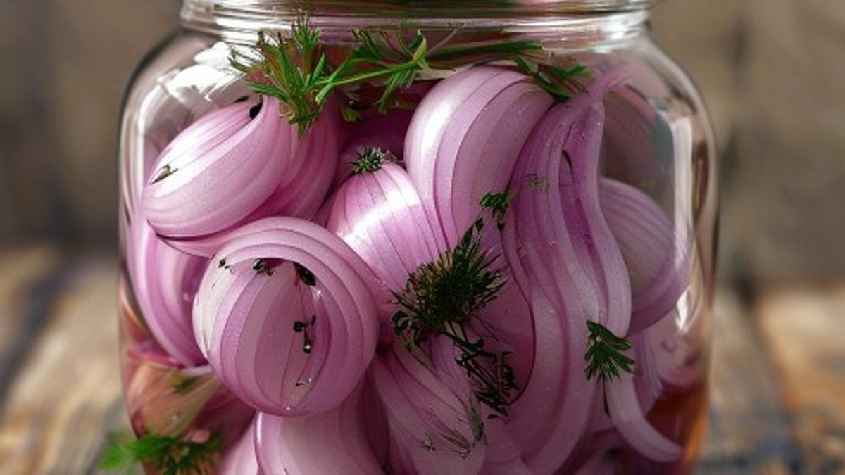 Photo of a jar of vibrantly colored, thinly sliced pickled red onions, proving the successful outcome and visual appeal of the expert pickling process.