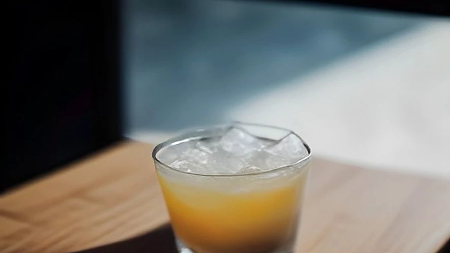 Bartender shaking a stainless steel cocktail shaker filled with ice and ingredients