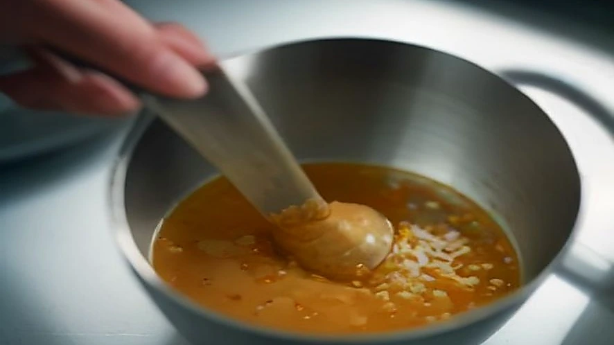 Hand crushing whole spices in a stainless steel mortar and pestle
