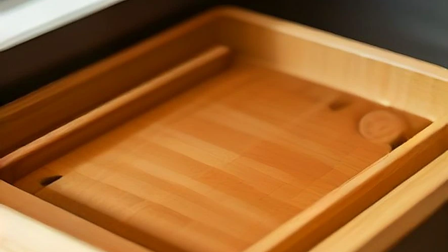 Bamboo drawer organizer holding forks, knives, and spoons in a kitchen drawer