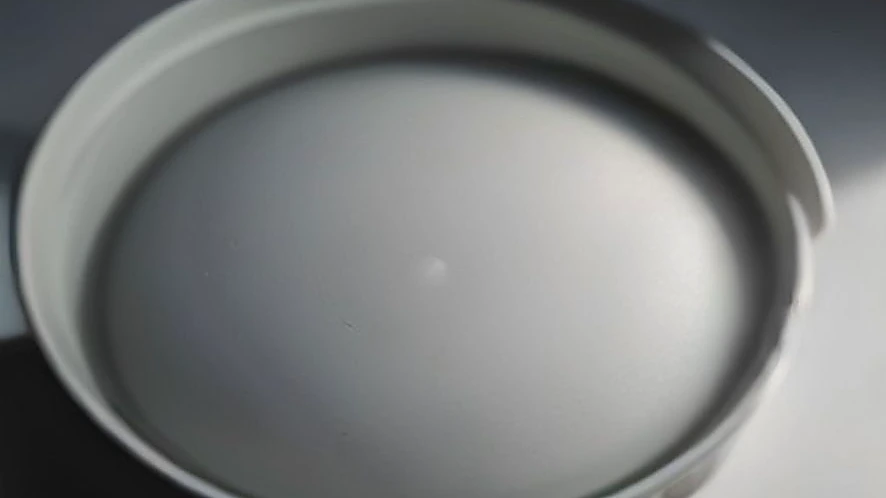 Detail of a pasta pot strainer lid with drain holes and secure locking handles