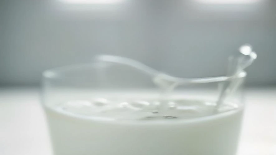 milk frother whisk creating foam inside a glass jug