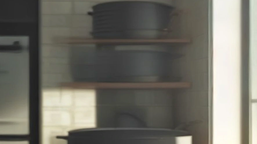 Compact wall-mounted pot rack in small kitchen holding pots, pans, and lids
