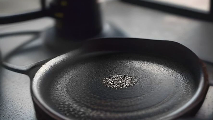 Cast iron tawa with chapati cooking over gas stove flame
