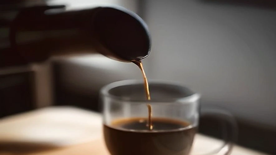 Drip coffee maker showerhead spraying water over coffee grounds for even extraction